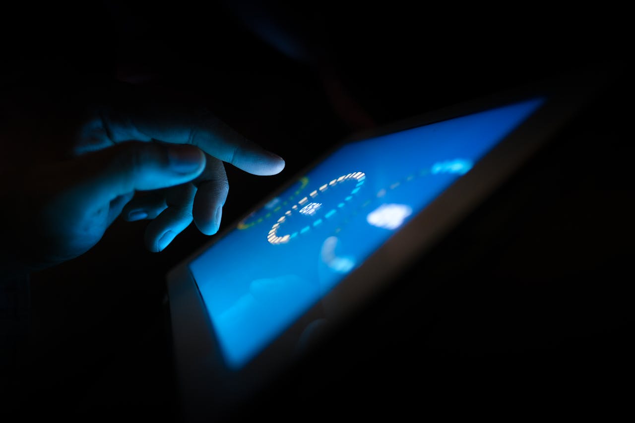 about-01 Close-up of a hand interacting with a glowing touchscreen in a dark setting, highlighting technology use.
